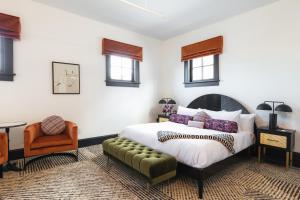 a bedroom with a large bed and a chair at Hotel Thaxter in Portsmouth