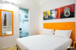 um quarto com uma cama branca e um espelho em Lia Art Hotel em La Spezia