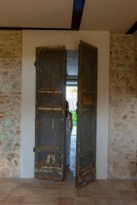 a woman is standing behind an open door at Relais Casale Valigi in Narni