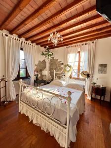 a bedroom with a white bed and a wooden ceiling at jasmine cottage in Luni