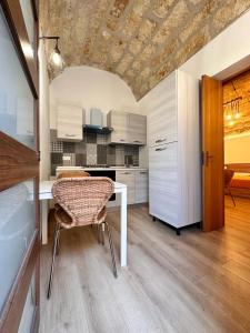 a kitchen with a table and chairs in a room at I Faraglioni Comfort Rooms in Terrasini