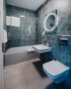 a bathroom with a toilet and a sink and a tub at Bay View Hotel in Kilkee