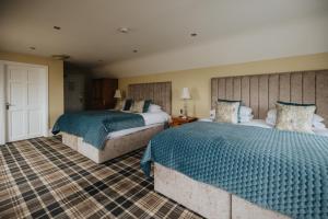 a bedroom with two beds with blue comforters at Bay View Hotel in Kilkee