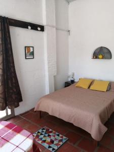 Un dormitorio con una cama con almohadas amarillas. en Apartamento 2 ambientes + baño Las Toscas SUR, en Las Toscas