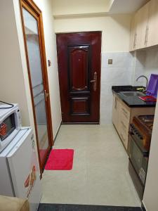 a kitchen with a brown door and a red rug at Lux Suites Dennis Pritt studio Apartments Kilimani in Nairobi