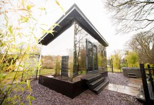 a small house with a glass door in a garden at Reflections, Netherby, near Carlisle in Longtown