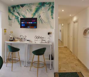 a kitchen with two green bar stools and a counter at PANORAMICO in Catania +22 photos