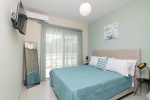 a bedroom with a blue bed and a window at Cinque Terre Iakinthi in Zakynthos Town +27 photos
