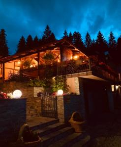 een huis met een trap die er 's nachts naartoe leidt bij Restoran sa sobama za iznajmljivanje MALI RAJ in Mrkonjić Grad