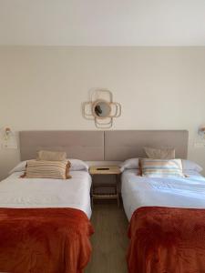 two beds sitting next to each other in a room at Pensión Cantabrico in Navia