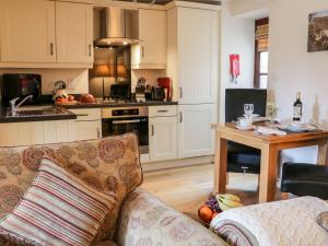 een woonkamer met een bank en een keuken bij The Threshing Floor at Tennant Barn in Skipton