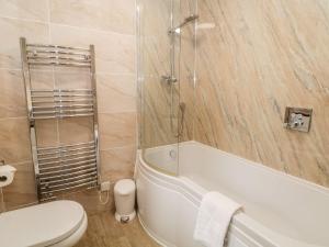 een badkamer met een bad, een toilet en een wastafel bij The Threshing Floor at Tennant Barn in Skipton