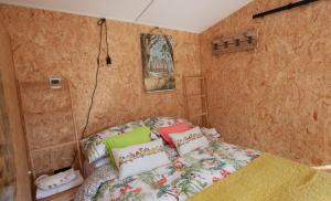 a small bedroom with a bed with colorful pillows at The Chard, Netherby, near Carlisle in Longtown