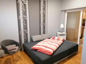 a bedroom with a black bed with a chair and a window at Casa Mediteran NEU in Reichensachsen