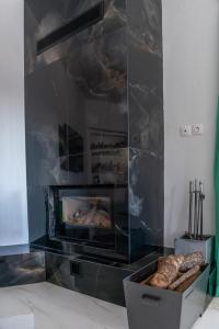 a living room with a fireplace and a tray of bread at Casa di Gio in Kalabaka