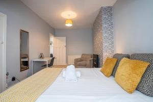 een slaapkamer met een groot wit bed met gele kussens bij 3 Bed Flat-Close to City Centre in Lemington