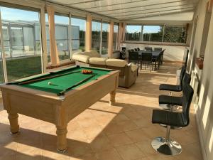 a pool table in the middle of a living room at Piscine chauffée Villa mouettes de Loire in Maslives