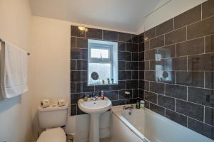 a bathroom with a sink and a toilet and a tub at 3 Bed Flat-Close to City Centre in Lemington
