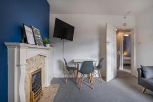 uma sala de estar com lareira e uma mesa e cadeiras em 3 Bed Flat-Close to City Centre em Lemington