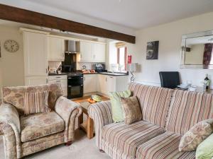 a living room with two couches and a kitchen at The Hayloft at Tennant Barn in Skipton
