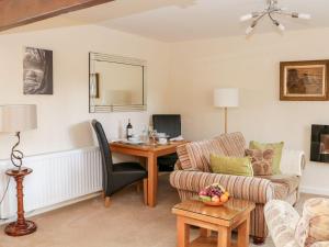 a living room with a table and a couch and a desk at The Hayloft at Tennant Barn in Skipton