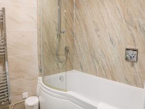 a bathroom with a shower and a tub and a toilet at The Hayloft at Tennant Barn in Skipton +17 photos