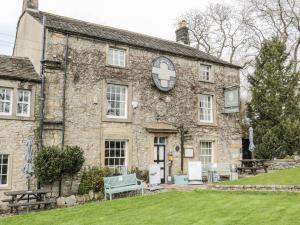 an old stone building with a clock on it at The Hayloft at Tennant Barn in Skipton