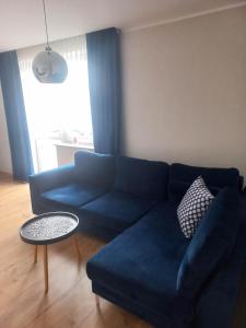 a living room with a blue couch and a table at Apartament w centrum Raciborza in Racibórz