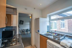 een kleine keuken met een wastafel en een raam bij 3 Bed Flat-Close to City Centre in Lemington