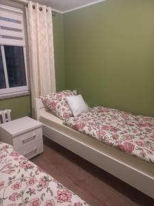 a bedroom with two beds and a window at Apartament w centrum Raciborza in Racibórz