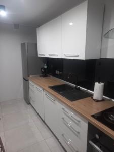 eine Küche mit weißen Schränken und einer Arbeitsplatte in der Unterkunft Apartament w centrum Raciborza in Ratibor