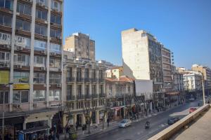 een drukke stadsstraat met hoge gebouwen en auto's bij URbAN DELUXE APARTMENTS AD in Thessaloniki
