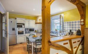una cocina con electrodomésticos blancos y una mesa con sillas. en Piscine chauffée Villa mouettes de Loire en Maslives