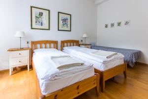 Habitación con 2 camas individuales y suelo de madera. en Casa Irina, en Riva del Garda