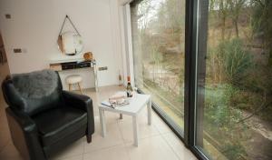 sala de estar con silla, mesa y ventana en The Heronry, Netherby, Near Carlisle, en Longtown