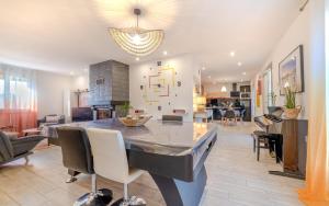 una cucina e un soggiorno con tavolo e sedie di ForestPlage Gîte avec SPA nordique a Cognac-le-Froid
