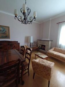 sala de estar con mesa, sillas y chimenea en Casa JUCALI en Tandil