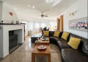 uma sala de estar com um sofá de couro preto e uma lareira em Villa Bravo em Partaloa