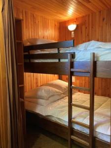 a room with two bunk beds in a cabin at Au Coeur du village de Prémanon in Prémanon