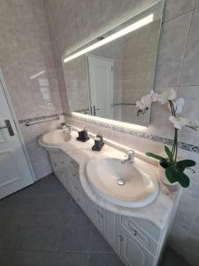 a bathroom with two sinks and a large mirror at Portimão Paradise - Spacious Family Villa in Portimão +24 photos
