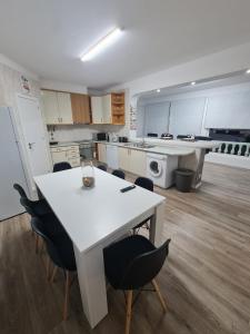 a large kitchen with a white table and chairs at Portimão Paradise - Spacious Family Villa in Portimão