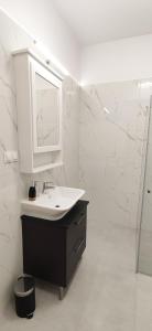 a white bathroom with a sink and a mirror at Apartament na Letniej 53m2 z Widokiem na Góry Kłodzko - Przyjaciół Ziemi Kłodzkiej in Kłodzko