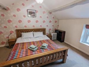a bedroom with a bed with two towels on it at ELM HOUSE COTTAGE - 2 Bed Cottage in High Hesket on the edge of the Lake District, Cumbria in High Hesket