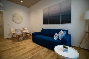 a living room with a blue couch and a table at La Cementina in Bari