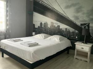 ein Schlafzimmer mit einem großen weißen Bett mit einem Wandgemälde einer Stadt in der Unterkunft Piscine chauffée Villa mouettes de Loire in Maslives
