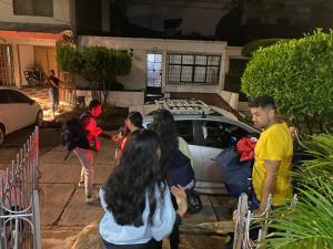 een groep mensen die voor een auto staan bij Casa Olimpico Hostal in Cali