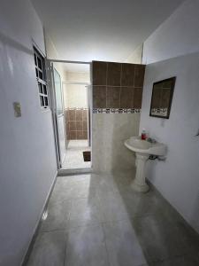 a white bathroom with a sink and a shower at Casa Grace in Emiliano Zapata