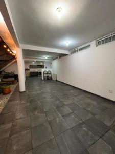 a large room with a white wall and a tile floor at Casa Grace in Emiliano Zapata