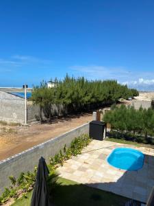 a view of the beach from the balcony of a house at Duplex vista mar acomoda até 12 pessoas com piscina e estacionamento privativo in Canoa Quebrada +6 photos