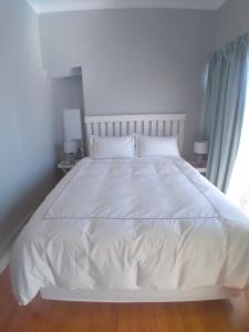 a white bed with white sheets and pillows in a bedroom at 16 on Point in Parow +12 photos